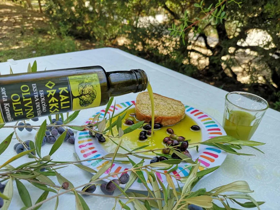 Oljčno olje Kali Oreksi se iz steklenice nateka na rezino kruha